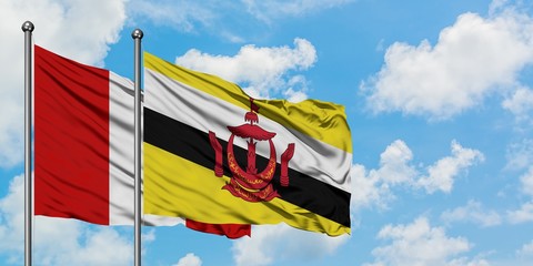 Peru and Brunei flag waving in the wind against white cloudy blue sky together. Diplomacy concept, international relations.