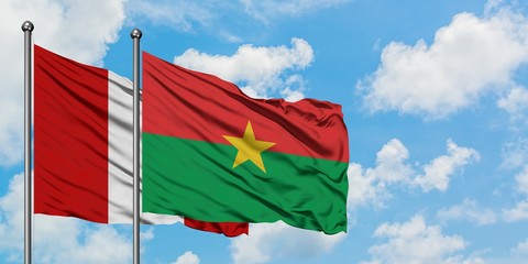 Peru and Burkina Faso flag waving in the wind against white cloudy blue sky together. Diplomacy concept, international relations.