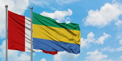 Peru and Gabon flag waving in the wind against white cloudy blue sky together. Diplomacy concept, international relations.