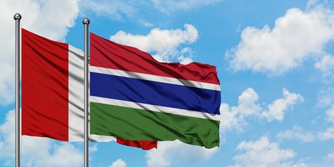 Peru and Gambia flag waving in the wind against white cloudy blue sky together. Diplomacy concept, international relations.