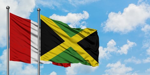 Peru and Jamaica flag waving in the wind against white cloudy blue sky together. Diplomacy concept, international relations.