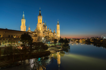 Fototapeta na wymiar View of the cathedral of El Pilar de Zaragoza (Spain) next to the river Ebro, at dusk.