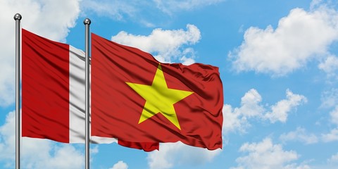 Peru and Vietnam flag waving in the wind against white cloudy blue sky together. Diplomacy concept, international relations.
