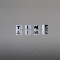 The concept of Time represented by black and white plastic letter cubes