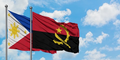 Philippines and Angola flag waving in the wind against white cloudy blue sky together. Diplomacy...