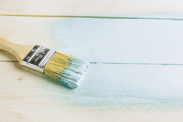 Paint brush with light blue paint on white background. Color of the Year 2020 - Bleached Coral. Renovation concept. Copy Space. Selective focus