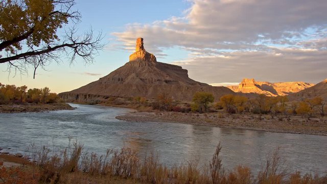 Panning view of the Green River as the sun lights up cliffs at Gunnison Butte in Utah at Swasey's Beach.