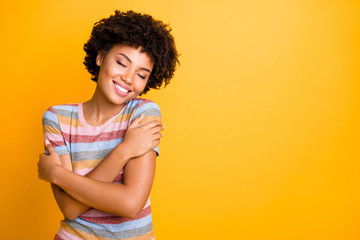 Photo of cheerful cute nice attractive youngster in her embrace enjoying comfortable striped t-shirt near empty space with toothy smile isolated over bright color background