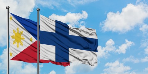 Philippines and Finland flag waving in the wind against white cloudy blue sky together. Diplomacy concept, international relations.