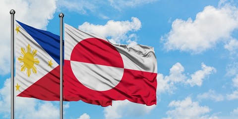 Philippines and Greenland flag waving in the wind against white cloudy blue sky together. Diplomacy concept, international relations.