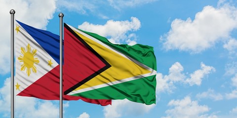 Philippines and Guyana flag waving in the wind against white cloudy blue sky together. Diplomacy concept, international relations.