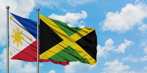 Philippines and Jamaica flag waving in the wind against white cloudy blue sky together. Diplomacy concept, international relations.