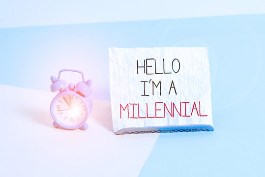 Conceptual hand writing showing Hello I M A Millennial. Concept meaning demonstrating reaching young adulthood in current century Alarm clock beside a Paper sheet placed on pastel backdrop