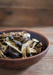 Sliced dried mushrooms lie in a clay plate close-up, copy space