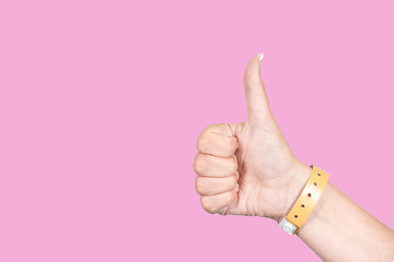 Close up side view of beautiful one female hand isolated on pink background. Woman showing thumb...