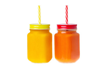 Two closeup glass jars of orange and yellow color smoothies with mango and papaya isolated at white background. Healthy vegan superfood lifestyle, detox dieting.