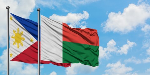 Philippines and Madagascar flag waving in the wind against white cloudy blue sky together. Diplomacy concept, international relations.