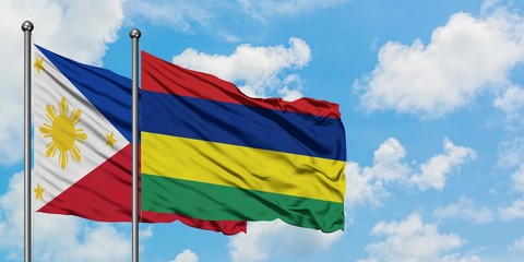 Philippines and Mauritius flag waving in the wind against white cloudy blue sky together. Diplomacy concept, international relations.