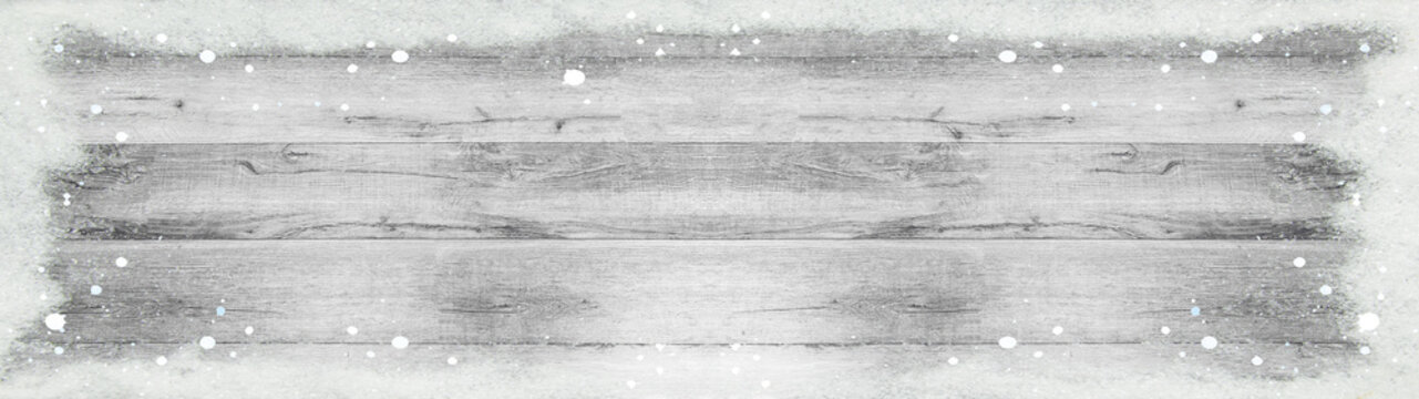 winter background - frame made of snow and snowflakes on bright light white grey rustic grunge wooden texture with space for text - top view, panorama banner long
