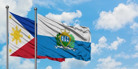 Philippines and San Marino flag waving in the wind against white cloudy blue sky together....