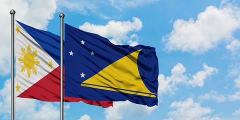 Philippines and Tokelau flag waving in the wind against white cloudy blue sky together. Diplomacy concept, international relations.