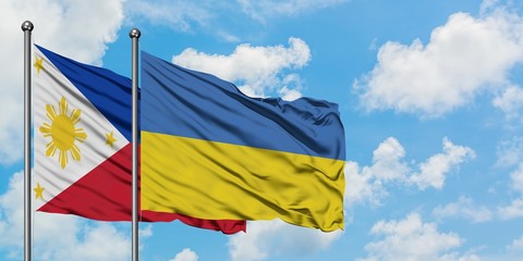Philippines and Ukraine flag waving in the wind against white cloudy blue sky together. Diplomacy...