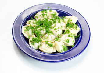 dumplings on a blue plate with sour cream