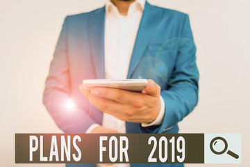 Writing note showing Plans For 2019. Business concept for an intention or decision about what one is going to do Business concept with man holding mobile phone with touch screen