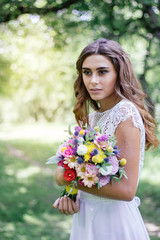 Obraz premium Wedding scene - bride with flower bouquet outdoor