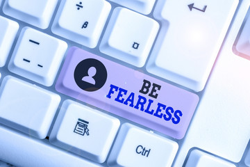 Conceptual hand writing showing Be Fearless. Concept meaning act of living in spite of those things that scare you to death White pc keyboard with note paper above the white background