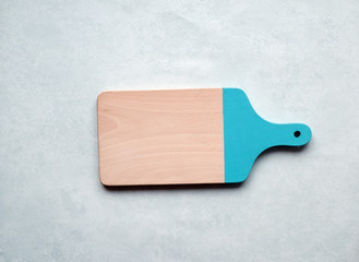 Wooden cutting board on gray concrete background. Table top view and copy space for text. Restaurant menu, recipe, food background mock up. Copy space