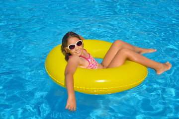 Real adorable girl relaxing in swimming pool