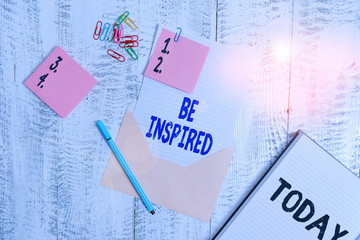 Word writing text Be Inspired. Business photo showcasing give oneself the desire or enthusiasm to do something well Envelope sheet paper sticky notes ballpoint notepad clips wooden background