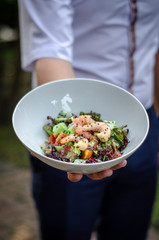  the waiter holds a plate with salad