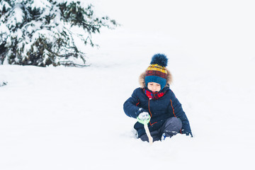 Fototapeta na wymiar boy playing with a shovel in the snow
