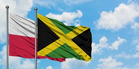 Poland and Jamaica flag waving in the wind against white cloudy blue sky together. Diplomacy concept, international relations.