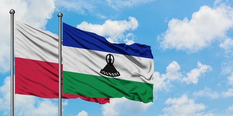 Poland and Lesotho flag waving in the wind against white cloudy blue sky together. Diplomacy...