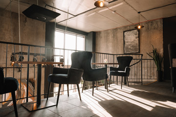 balcony with tables and chairs in modern loft coffee house in sunlight