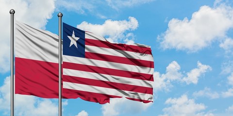Poland and Liberia flag waving in the wind against white cloudy blue sky together. Diplomacy concept, international relations.
