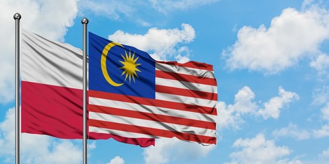 Poland and Malaysia flag waving in the wind against white cloudy blue sky together. Diplomacy concept, international relations.