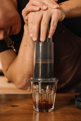 partial view of barista preparing coffee with aeropress