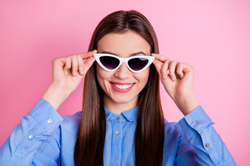 Naklejka premium Close up photo of cute nice fascinating good lady wearing sunglass eyewear holding them with hands smiling toothily isolated over pink pastel color background