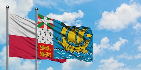 Poland and Saint Pierre And Miquelon flag waving in the wind against white cloudy blue sky together. Diplomacy concept, international relations.