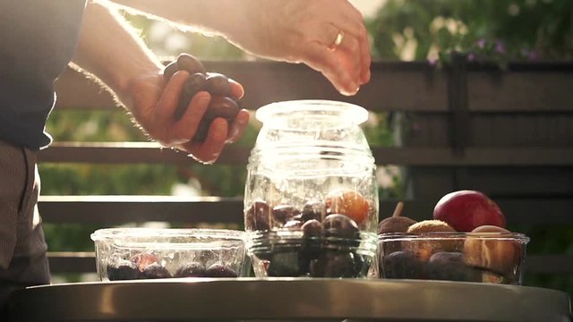 Hand adding fruits to the jar, super slow motion