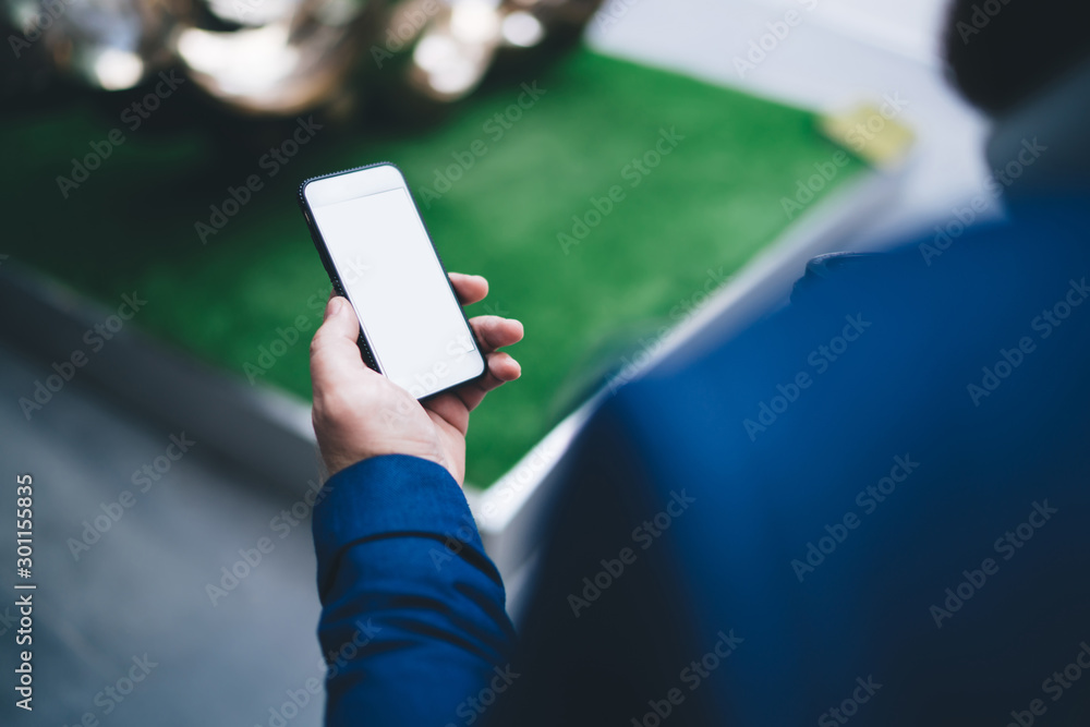 Poster cropped image of man using cellphone device with mock up screen for digital marketing and updating m