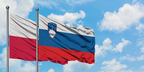 Poland and Slovenia flag waving in the wind against white cloudy blue sky together. Diplomacy concept, international relations.