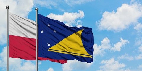 Poland and Tokelau flag waving in the wind against white cloudy blue sky together. Diplomacy concept, international relations.