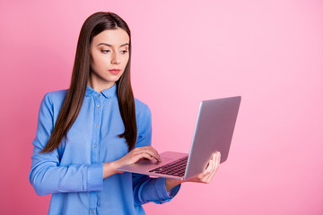 Photo of serious concentrated confident attorney working on assignment she received holding computer with her hands isolated over pastel color background