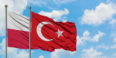 Poland and Turkey flag waving in the wind against white cloudy blue sky together. Diplomacy concept, international relations.