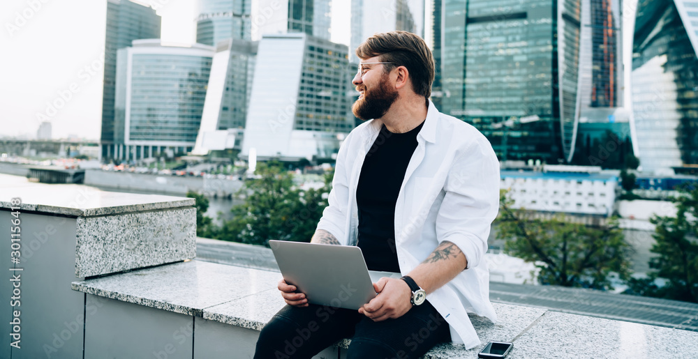 Aufkleber positive male software developer dreaming about statup project sitting in downtown with open modern 